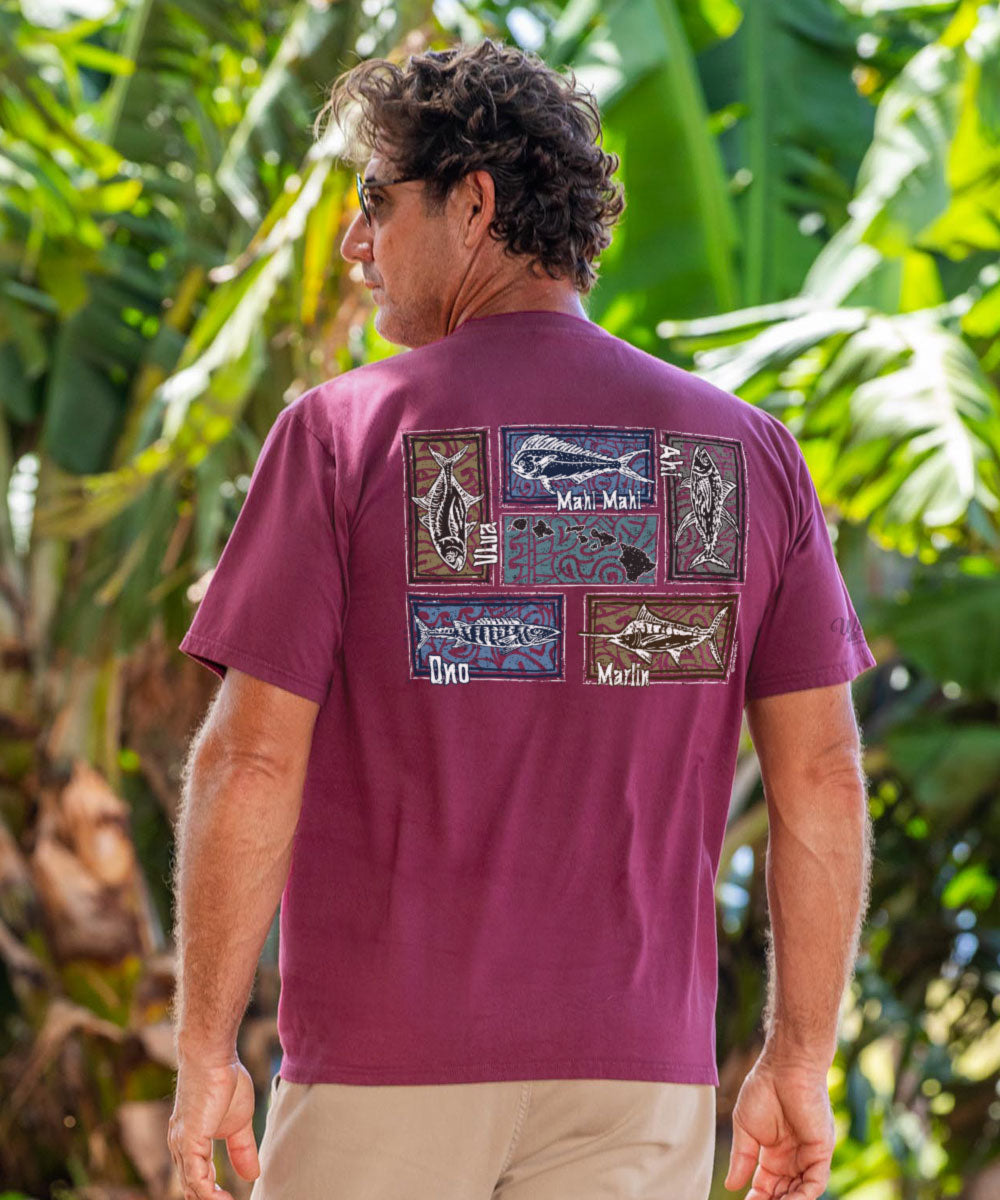Man wearing a maroon t-shirt with fishing-themed designs in a tropical setting View 2