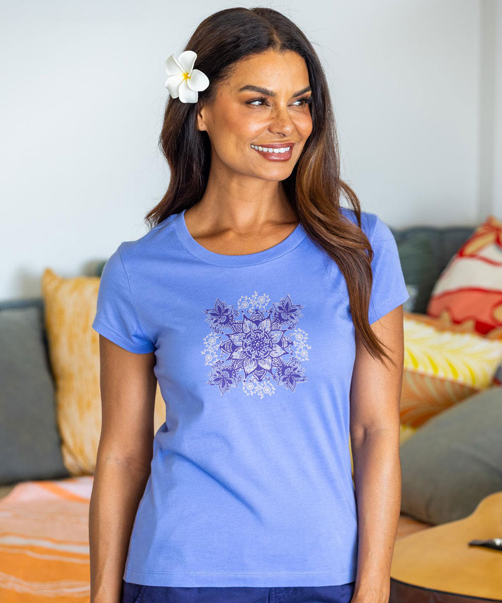 Woman wearing a blue t-shirt with a floral design, standing in a casual indoor setting. View 2