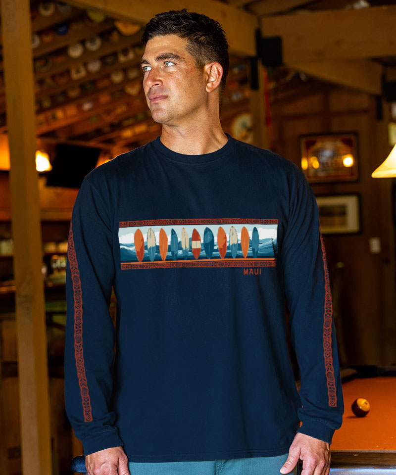 Man wearing a navy long-sleeve shirt with a colorful surfboard design in a casual setting. View 2