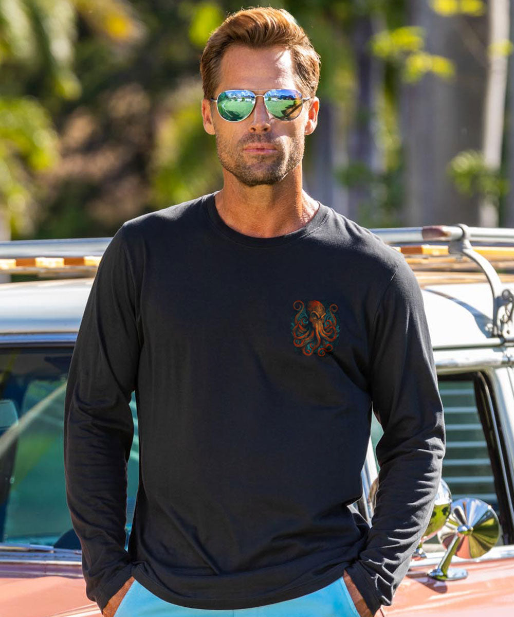Man wearing a black long-sleeve shirt with an octopus pocket design, standing next to a vintage car. View 3