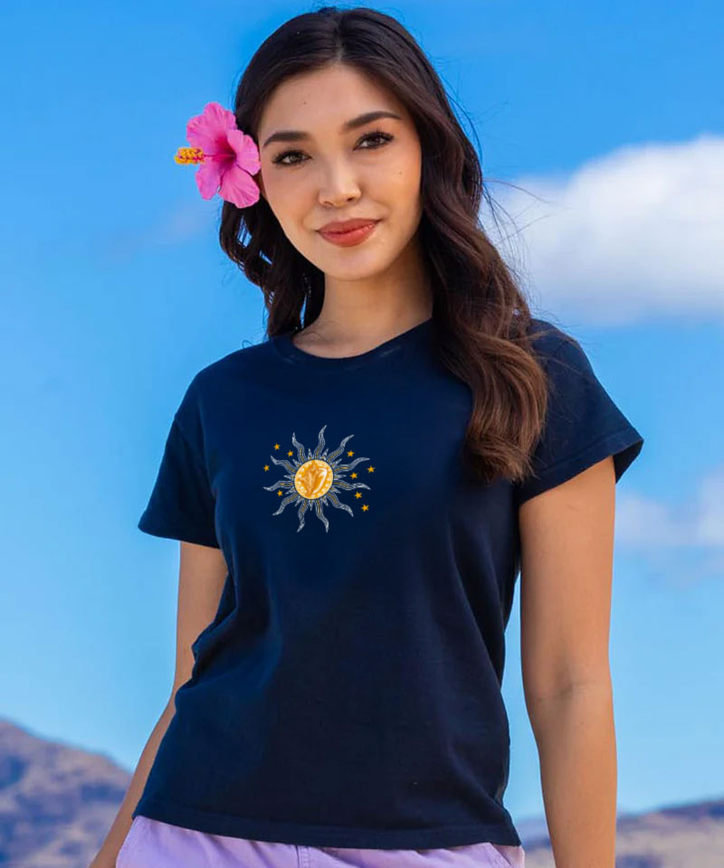 Woman wearing a navy blue t-shirt with a sun design against a blue sky background View 3
