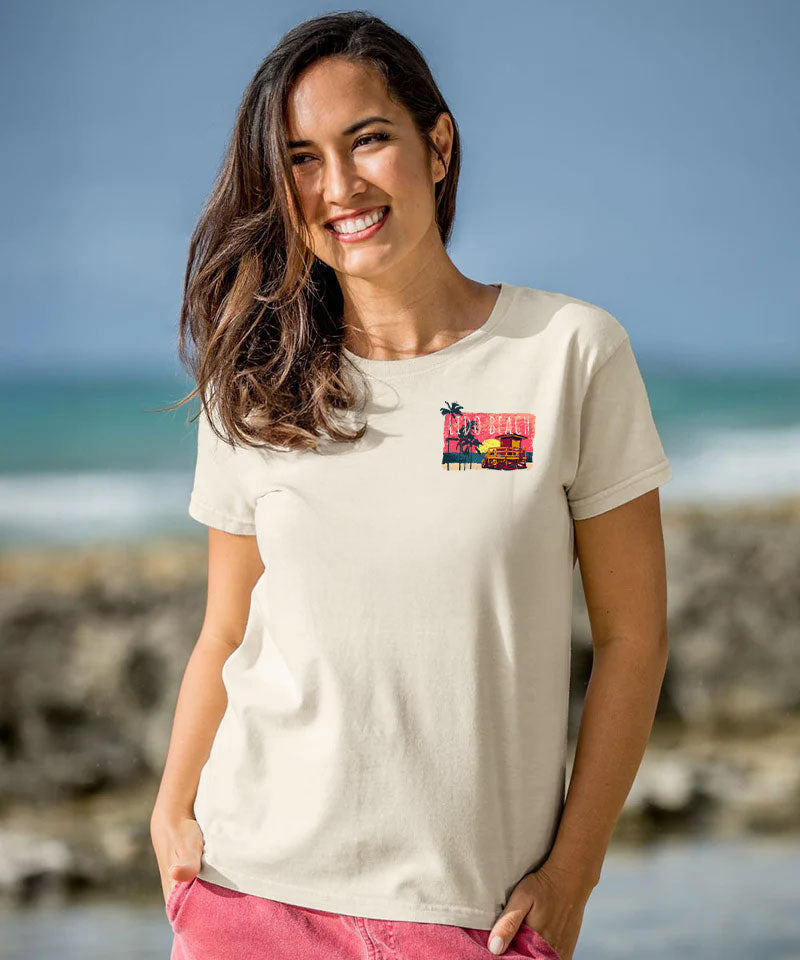 Woman wearing a white t-shirt with a colorful graphic on a beach View 3