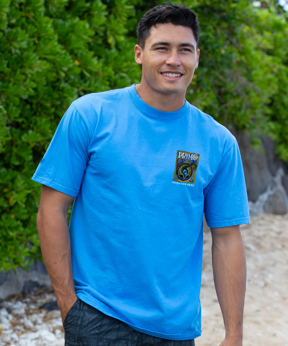 Man wearing a blue t-shirt with a logo standing outdoors View 3