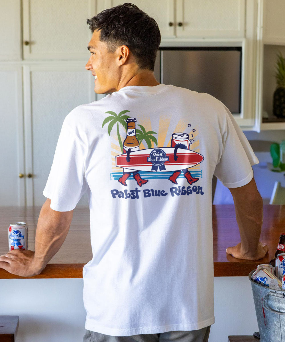Man wearing a white t-shirt with a colorful graphic design in a kitchen. View 2