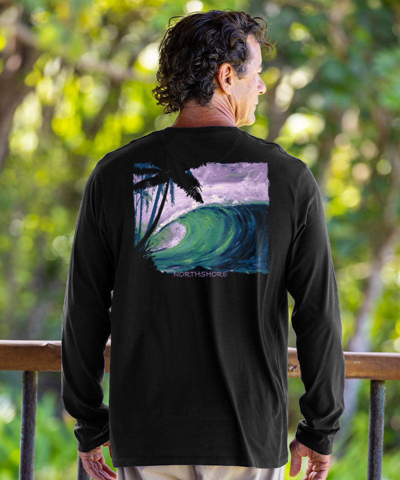 Man wearing a black long-sleeve shirt with a colorful wave design on the back, standing outdoors. View 2
