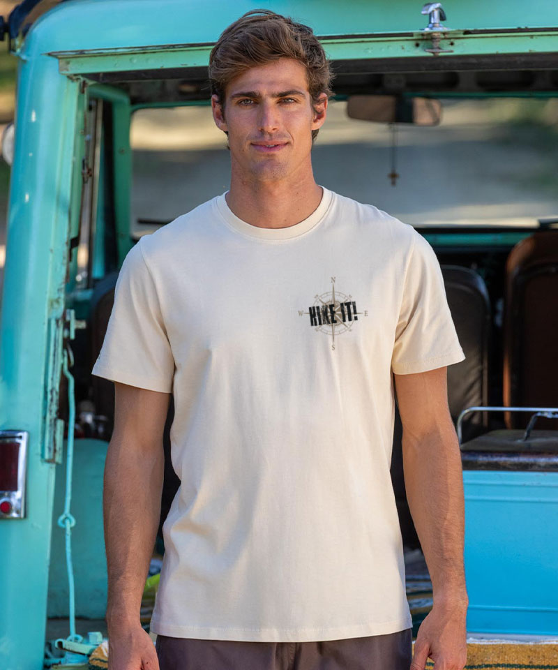 Man wearing a biege t-shirt standing in front of a vintage truck. View 3