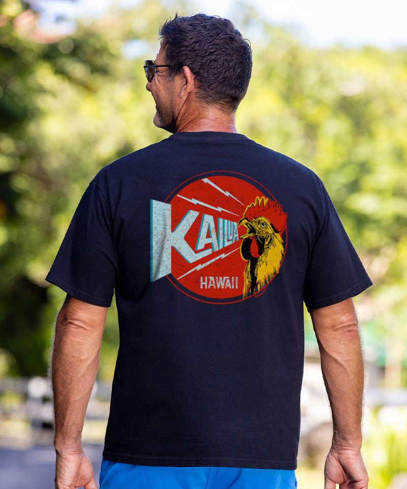 Man wearing a black t-shirt with a colorful graphic on the back, standing outdoors. View 2