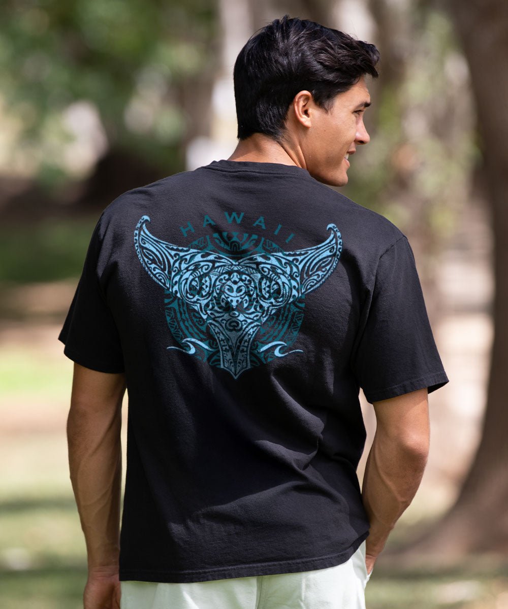 Man wearing a black t-shirt with blue Hawaii design, standing outdoors View 2