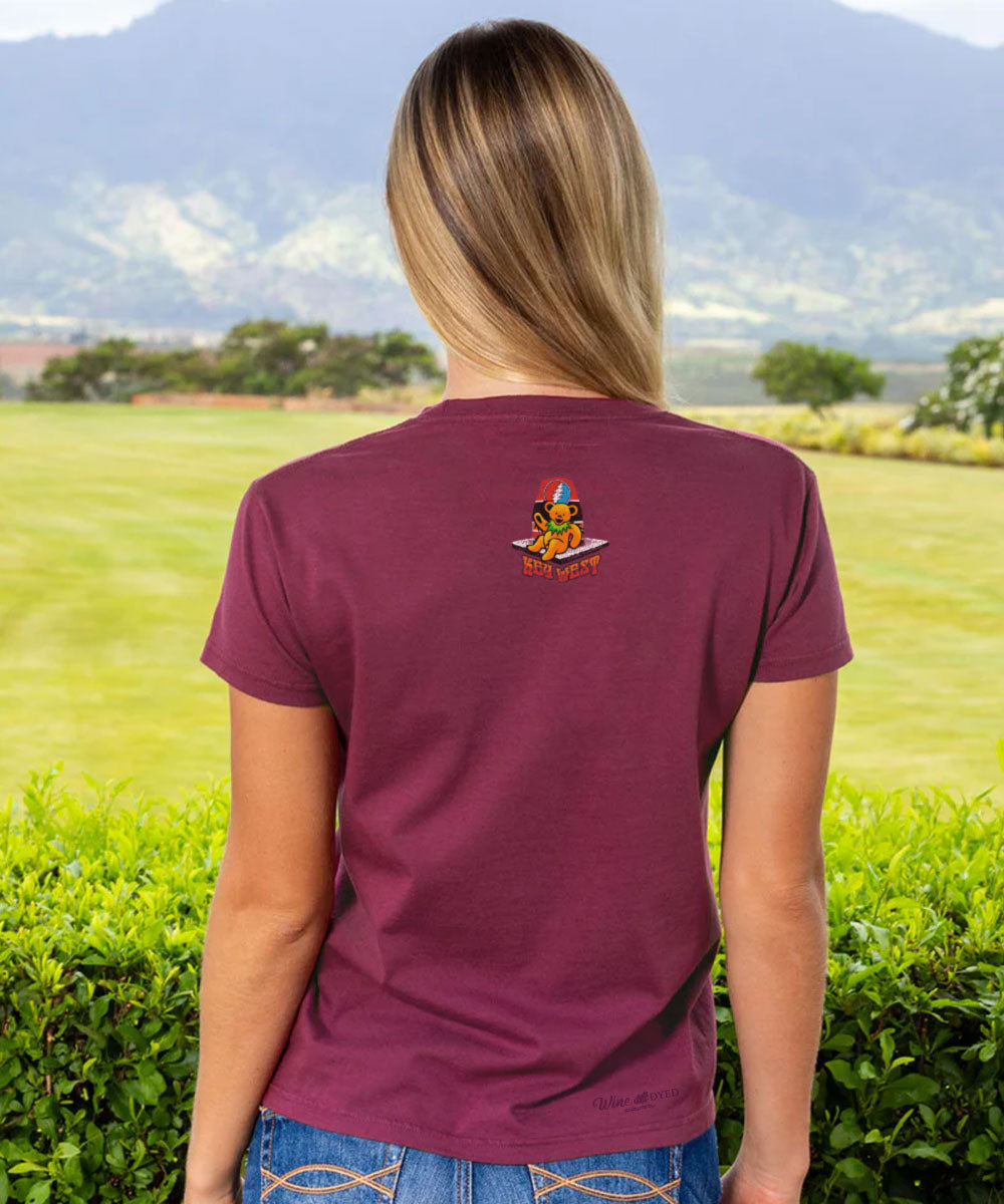 Person wearing a maroon t-shirt with a logo in a field View 3