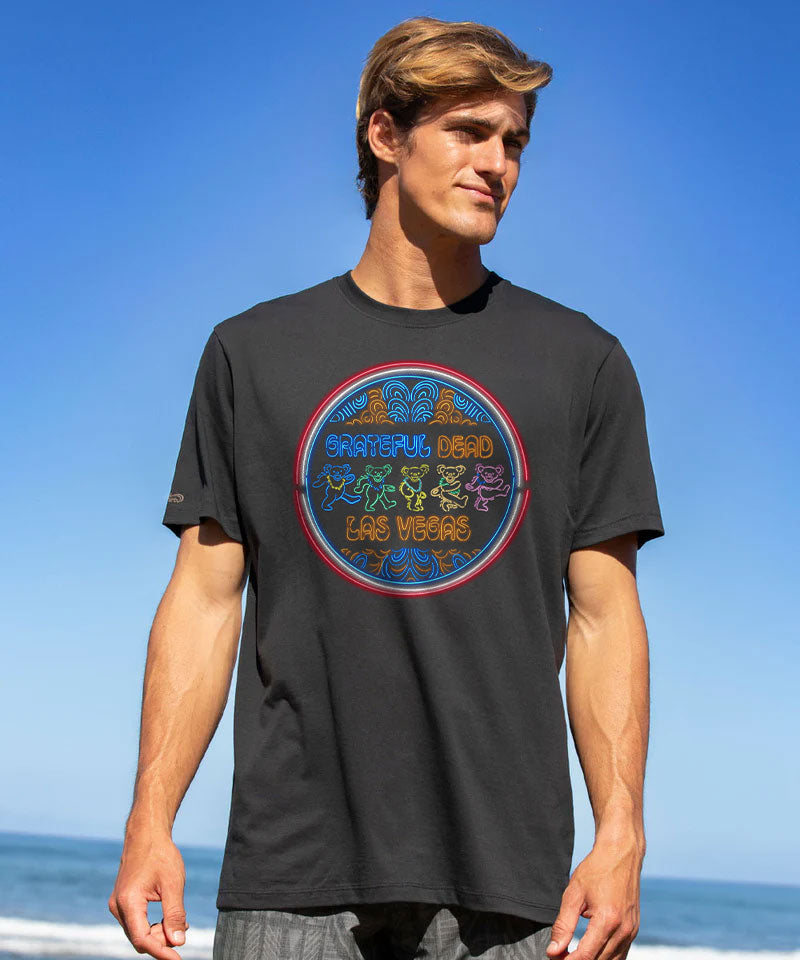 Man wearing a black t-shirt with a colorful graphic design on a beach View 2