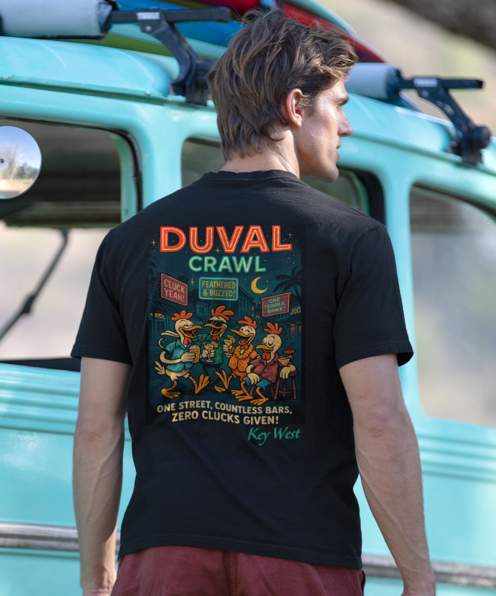 Man wearing a black t-shirt with a design on the back, stnading in front of a vehicle. View 2