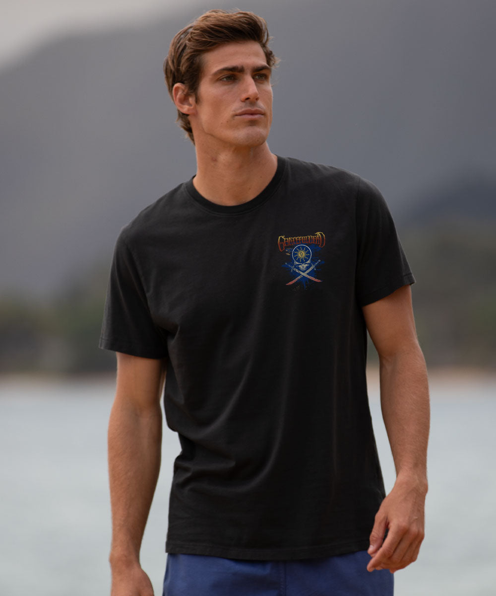Man wearing a black t-shirt with a logo by a body of water View 3
