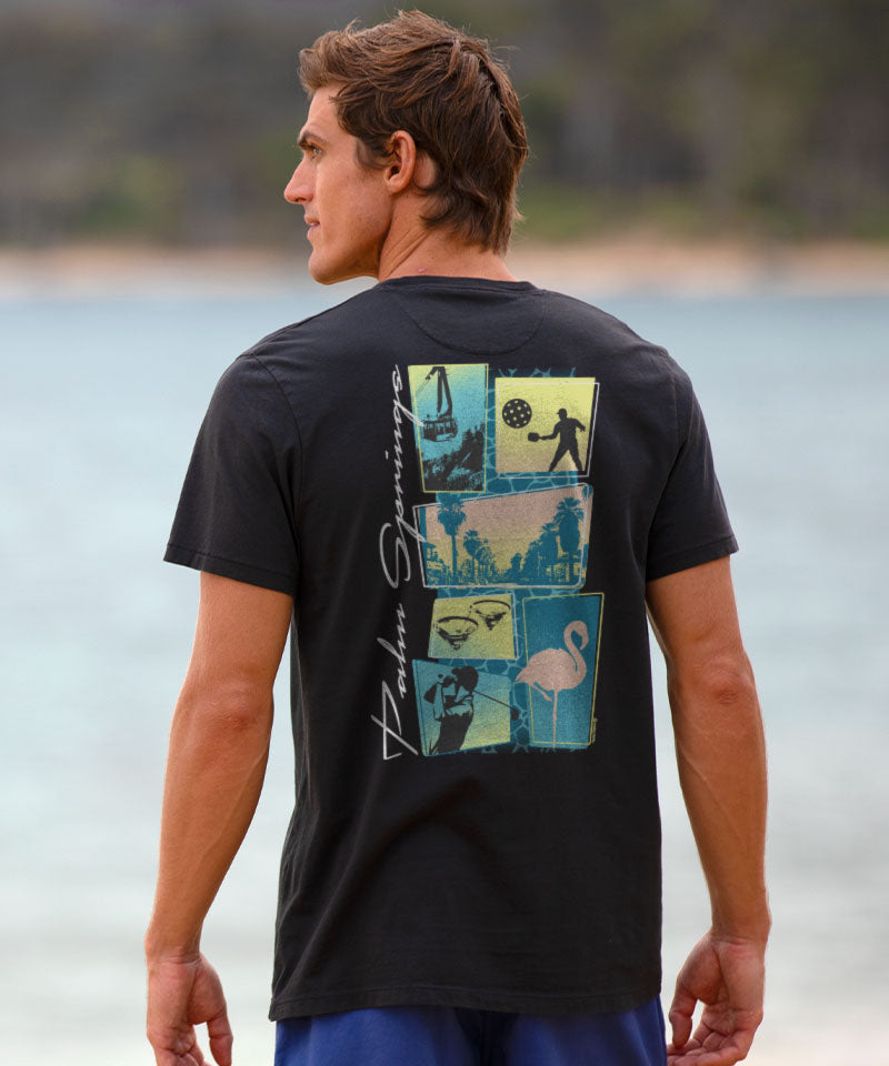 Man wearing a black t-shirt with a graphic on the back with the beach in the background View 2