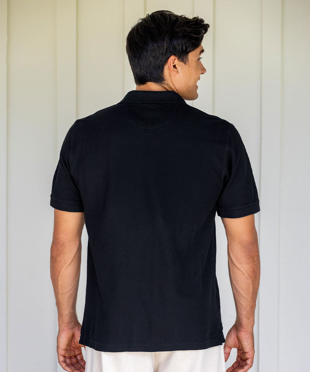 Man wearing a black polo shirt with a plain background View 3