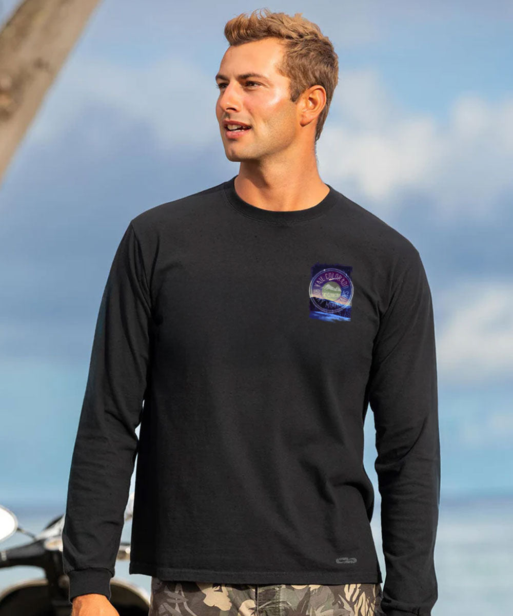 Man wearing a black long-sleeve shirt with a logo, standing outdoors. View 3