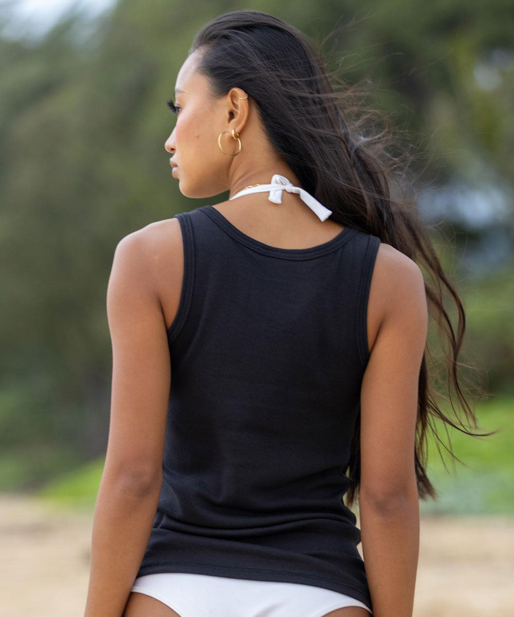 Woman wearing a black tank top with a blurred natural background View 3