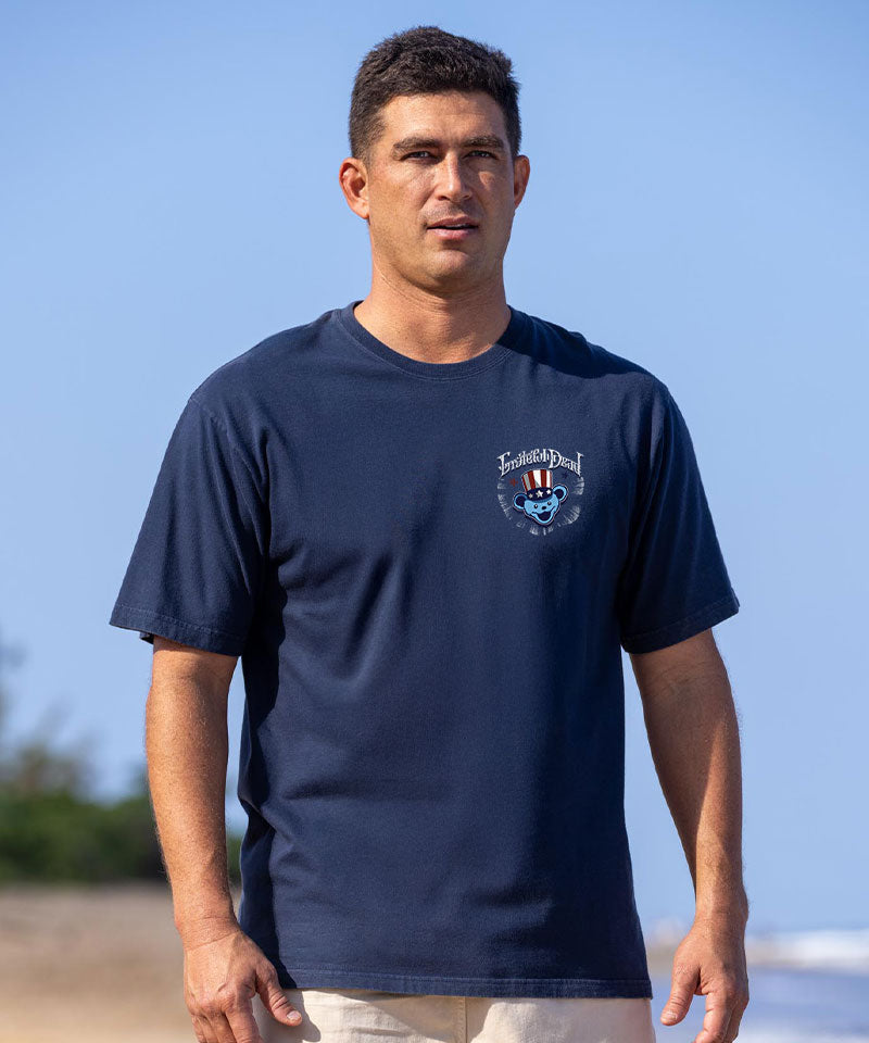 Man wearing a navy blue t-shirt with a logo on a beach View 3
