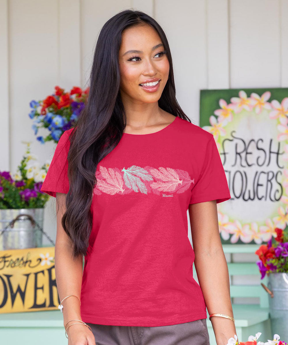 Woman wearing a raspberry dyed t-shirt with a white graphic design, standing in front of a floral arrangement and 'Fresh Flowers' sign. View 2