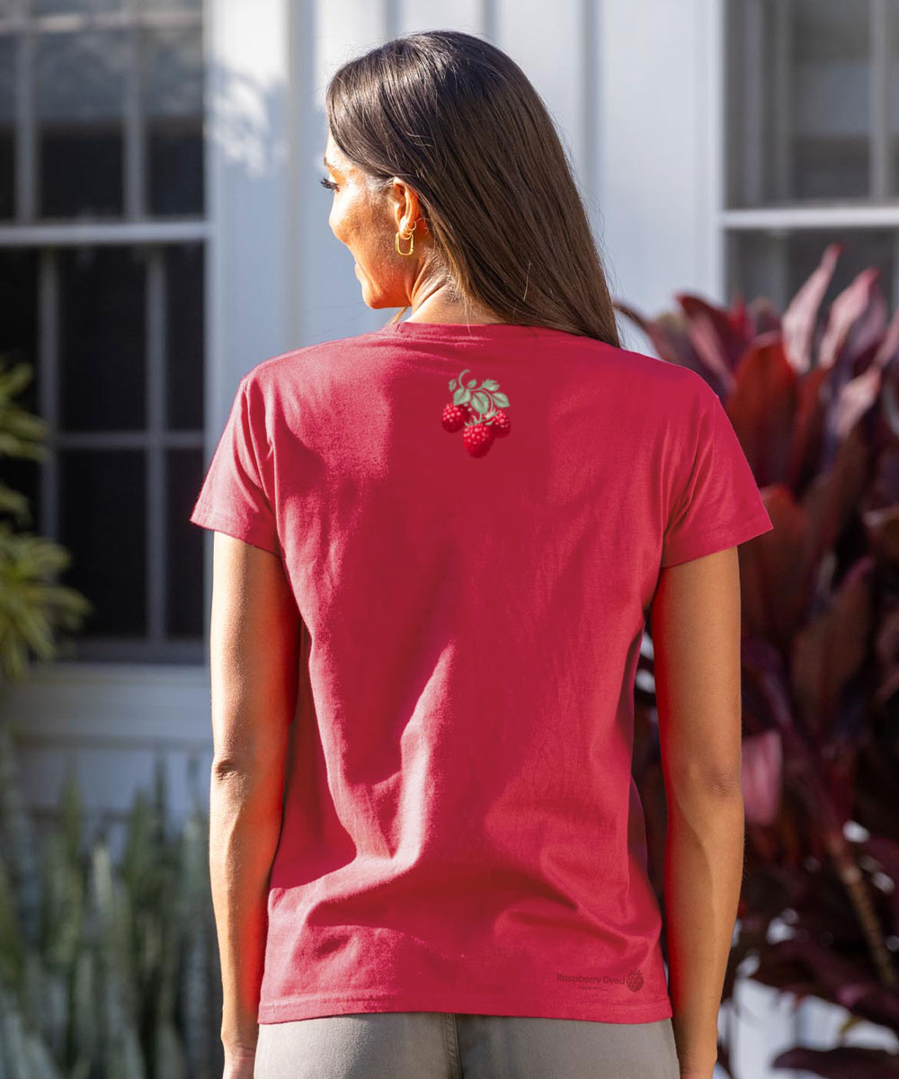 Person wearing a raspberry dyed t-shirt with a floral design on the back, standing outdoors. View 3