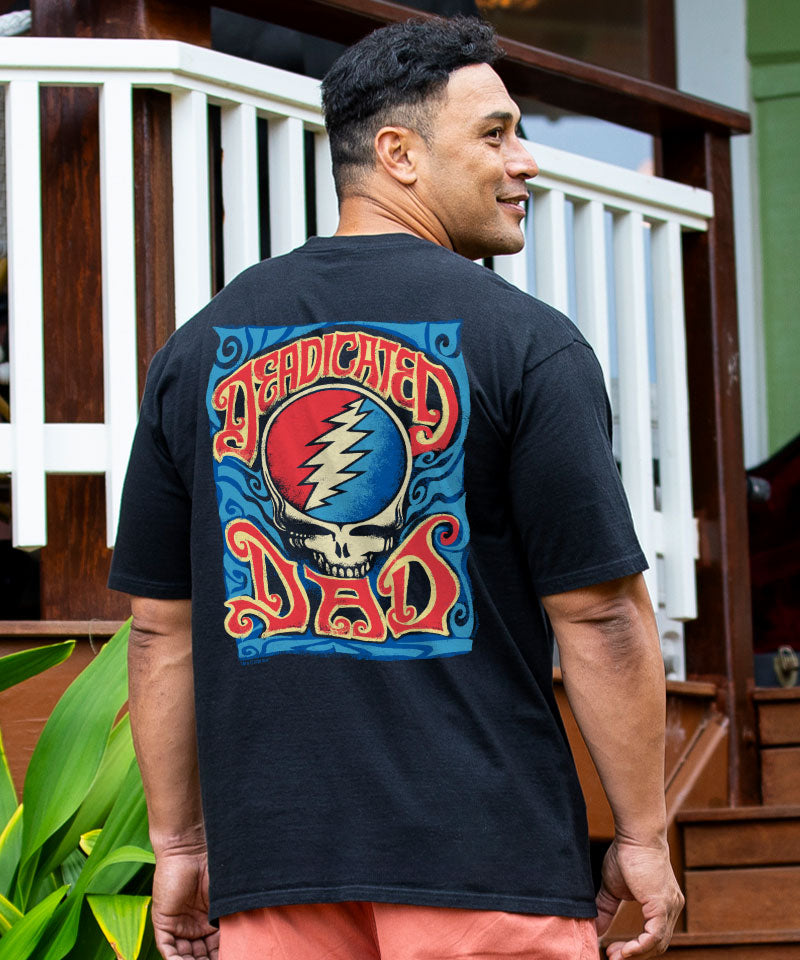 Man wearing a black t-shirt with a colorful design on the back, standing outdoors. View 2