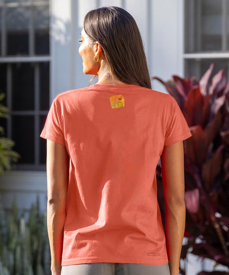 Woman wearing a coral t-shirt standing in front of a house View 3