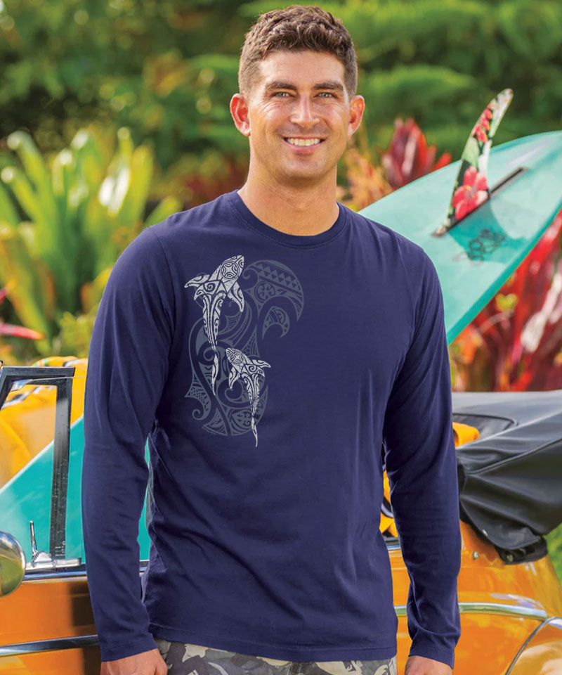 Man wearing a navy long-sleeve shirt with a shark design in front of a colorful kayak. View 2