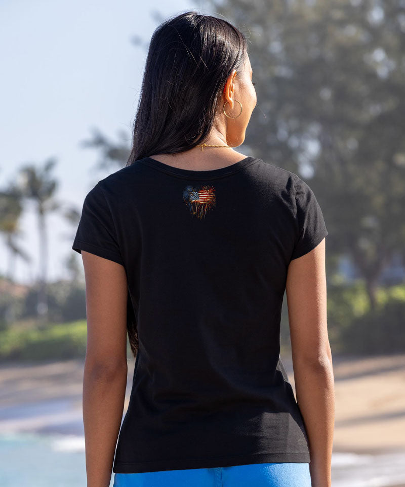 Person wearing a black t-shirt with a design on the back, standing outdoors. View 3