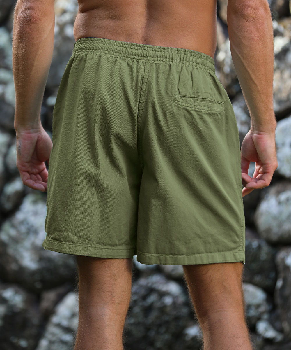 Person wearing green shorts standing against a rocky background View 3
