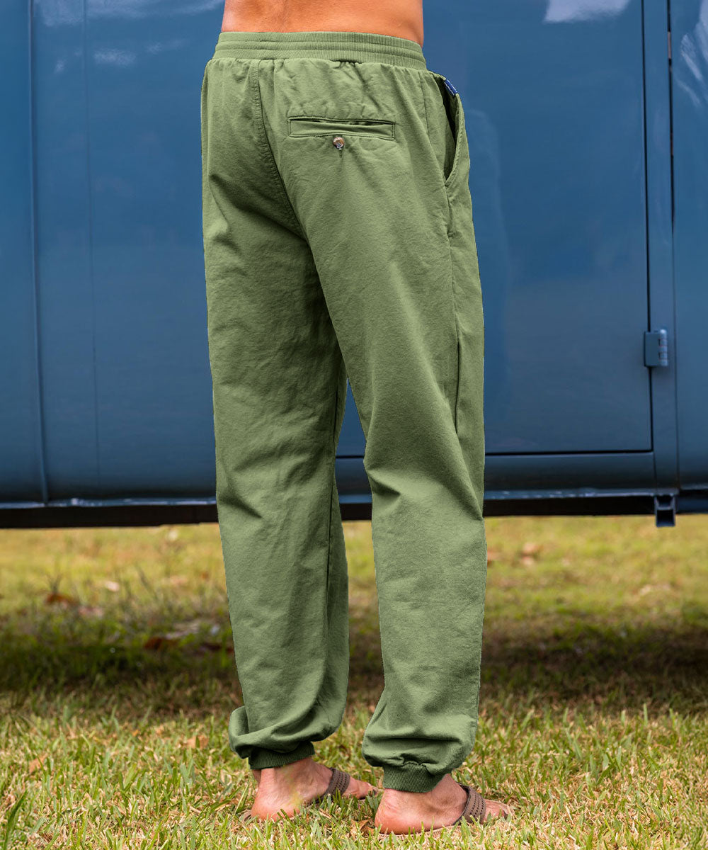 Man wearing green pants standing on grass View 3