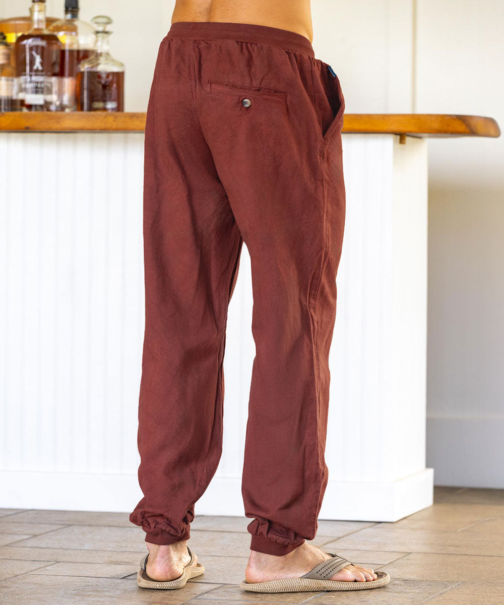 Man wearing reddish-brown pants standing in a room. View 3