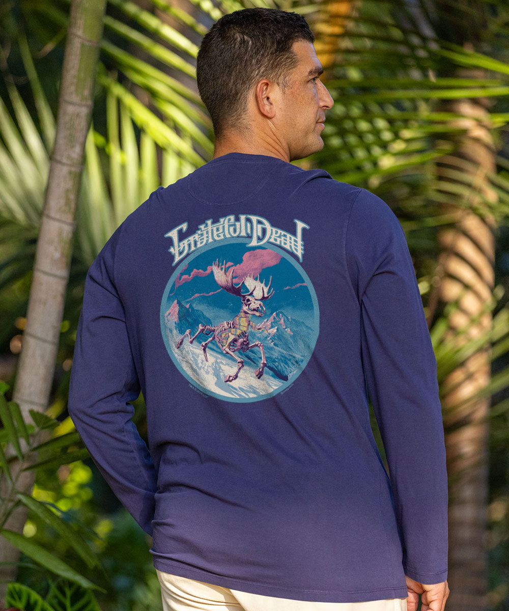 Man wearing a navy blue shirt with a graphic design, standing next to a teal kayak. View 2
