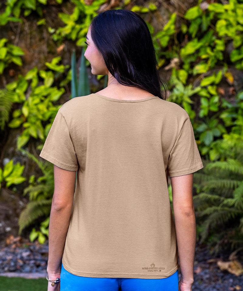 Woman wearing a beige t-shirt with a green leafy background View 3