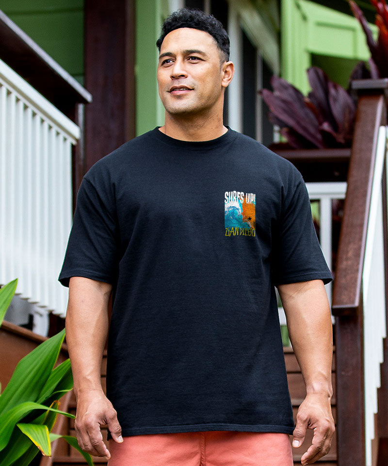 Man wearing a black t-shirt with a colorful graphic on a wooden deck View 3