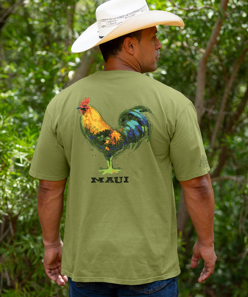 Man wearing a green t-shirt with a colorful rooster design and 'Kawai Pride' text, standing in a natural setting. View 2