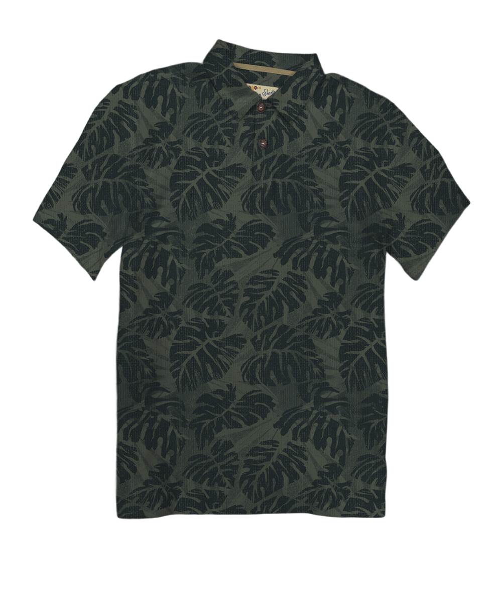 A short-sleeve polo shirt with an all-over dark tropical leaf pattern, featuring a collar and a three-button placket, shown against a plain white background. View 1