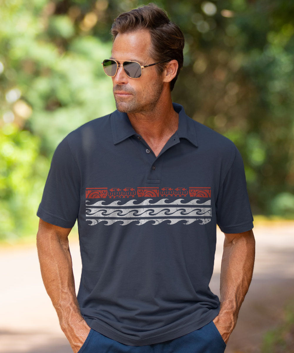 A man wearing a dark navy polo shirt with a horizontal graphic pattern across the chest, standing outdoors against a blurred green background. View 2