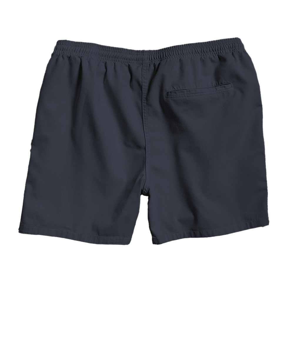 A pair of dark navy blue swim trunks with an elastic waistband and a side pocket, shown from the back on a white background. View 4