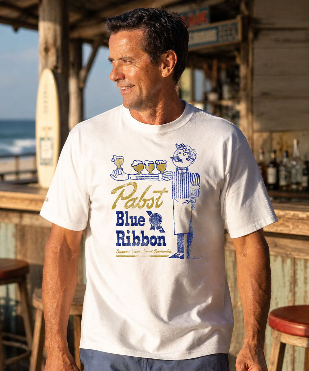 Man wearing a Pabst Blue Ribbon t-shirt by the ocean View 2