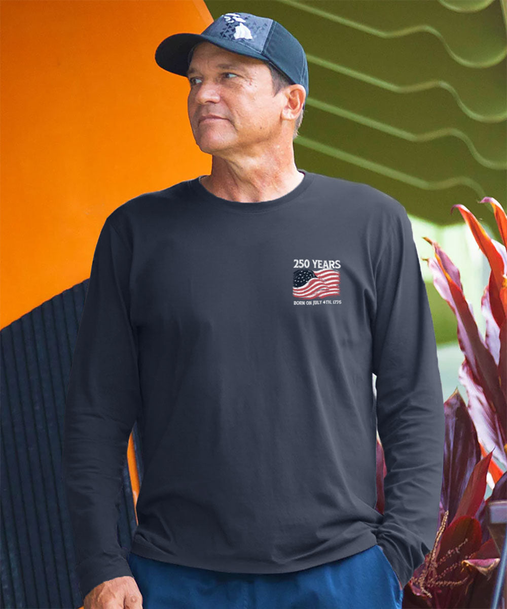 Man wearing a black long-sleeve shirt with a logo, standing against an orange and green background. View 3