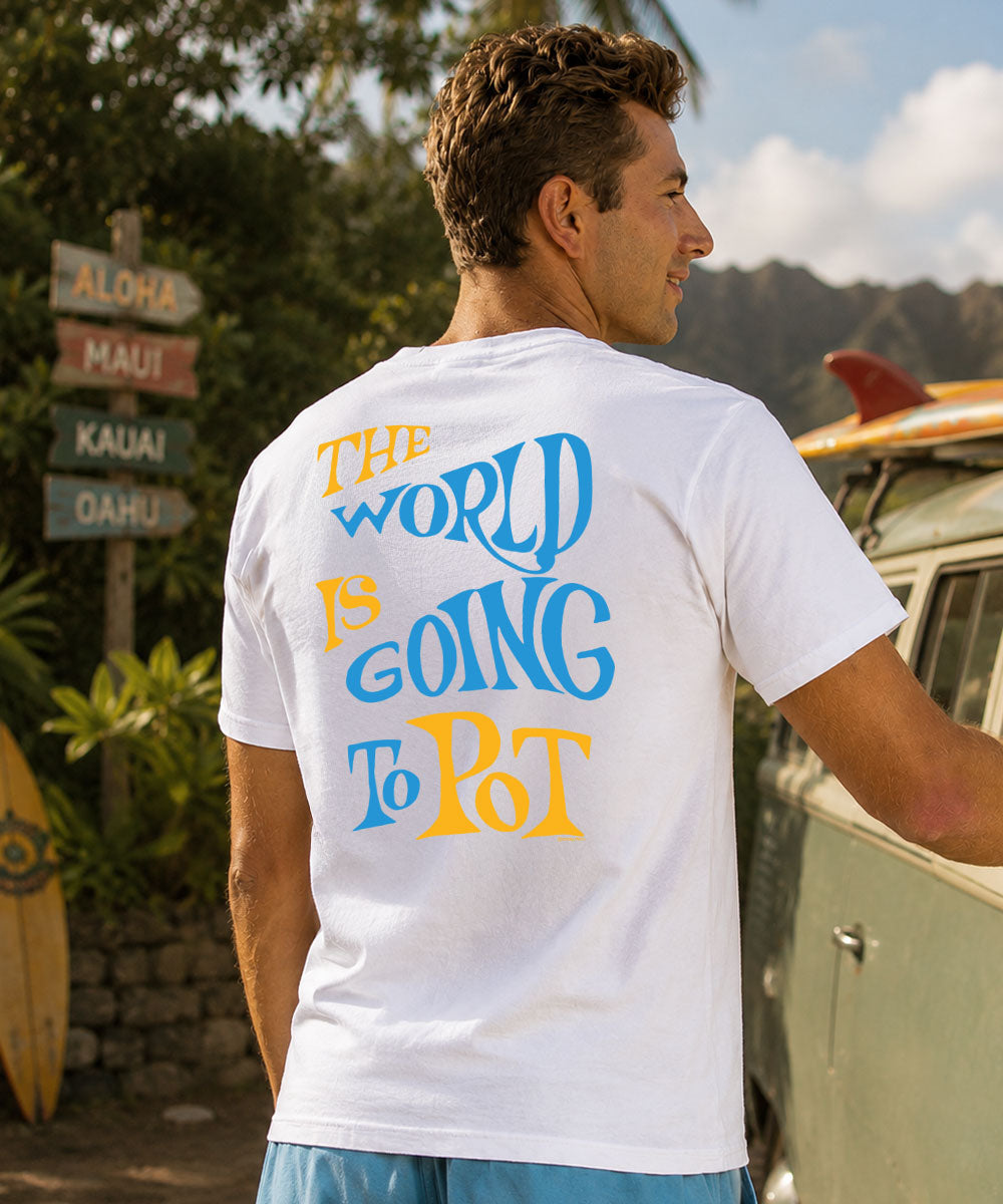 Man wearing a white t-shirt with colorful text, standing next to a yellow surfboard. View 2