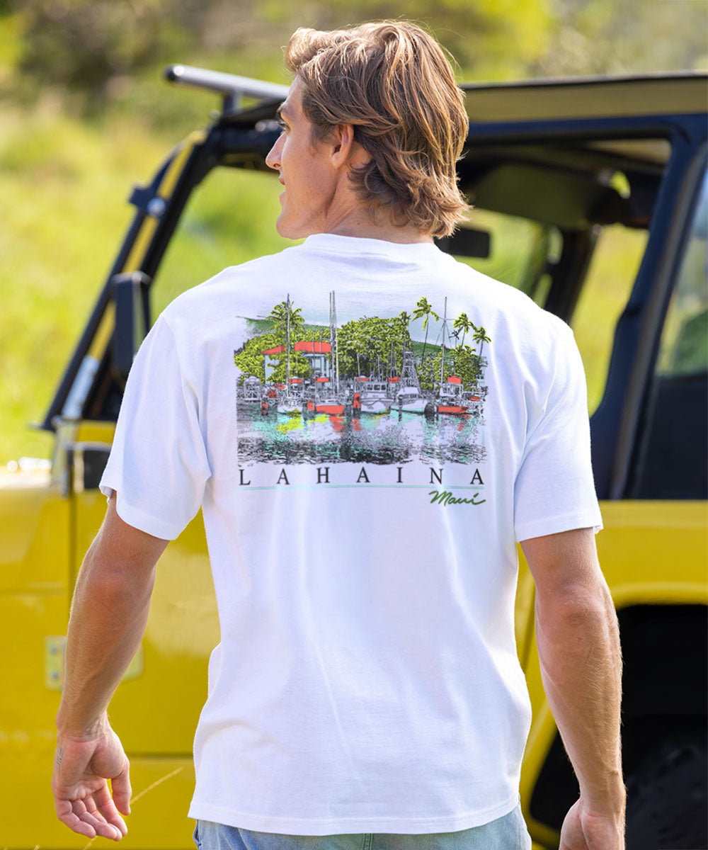 A man wearing a white short-sleeve polo shirt with a colorful graphic print of a tropical harbor scene and the text 'LAHAINA Maui' on the back, standing outdoors next to a yellow vehicle. View 2