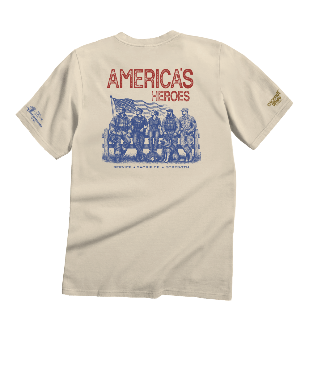 A beige short-sleeve t-shirt shown from the back, featuring a large graphic print with the text 'AMERICA'S HEROES' in red and a blue illustration of military figures and an American flag.