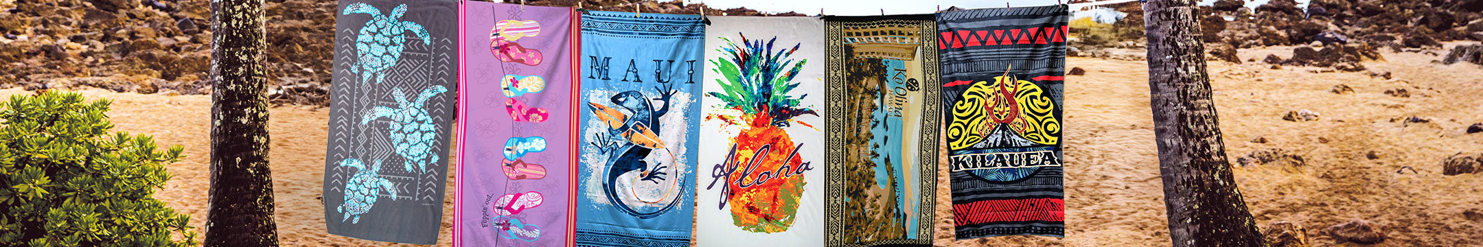 Row of colorful towels hanging on a line against a desert landscape with trees.