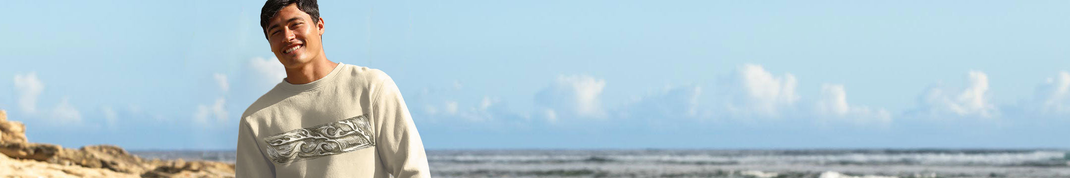 Person standing on a beach with ocean and sky in the background