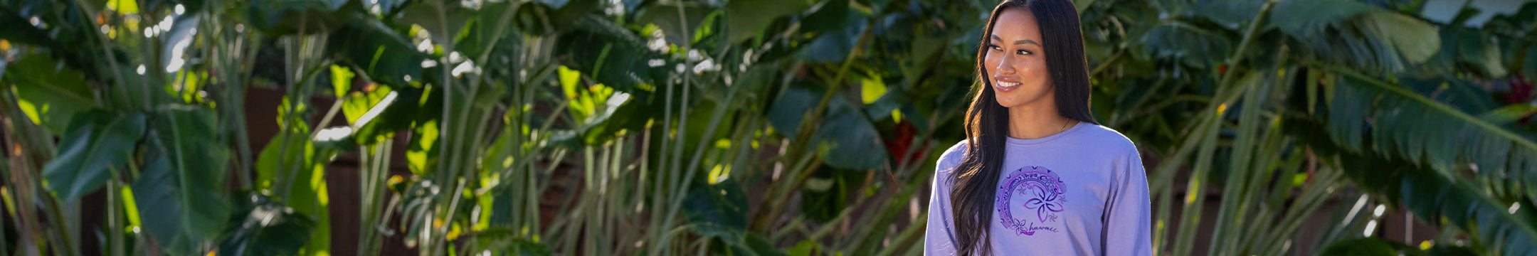 Person wearing a purple shirt standing in a lush green field