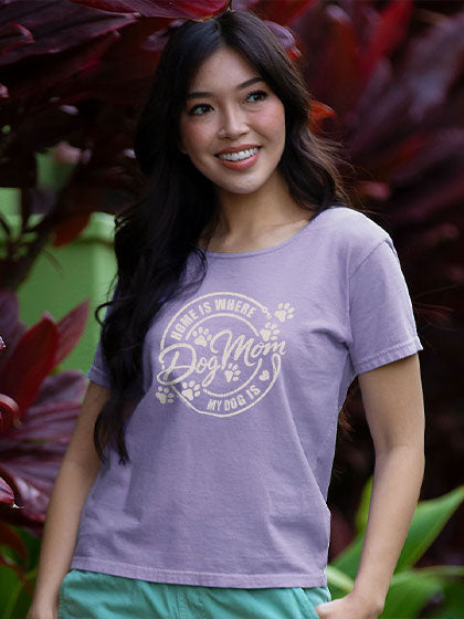 Woman wearing a purple t-shirt with 'Dog Mom' text in a natural setting