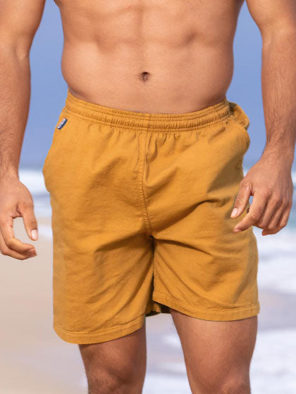 Person wearing mustard yellow shorts on a beach