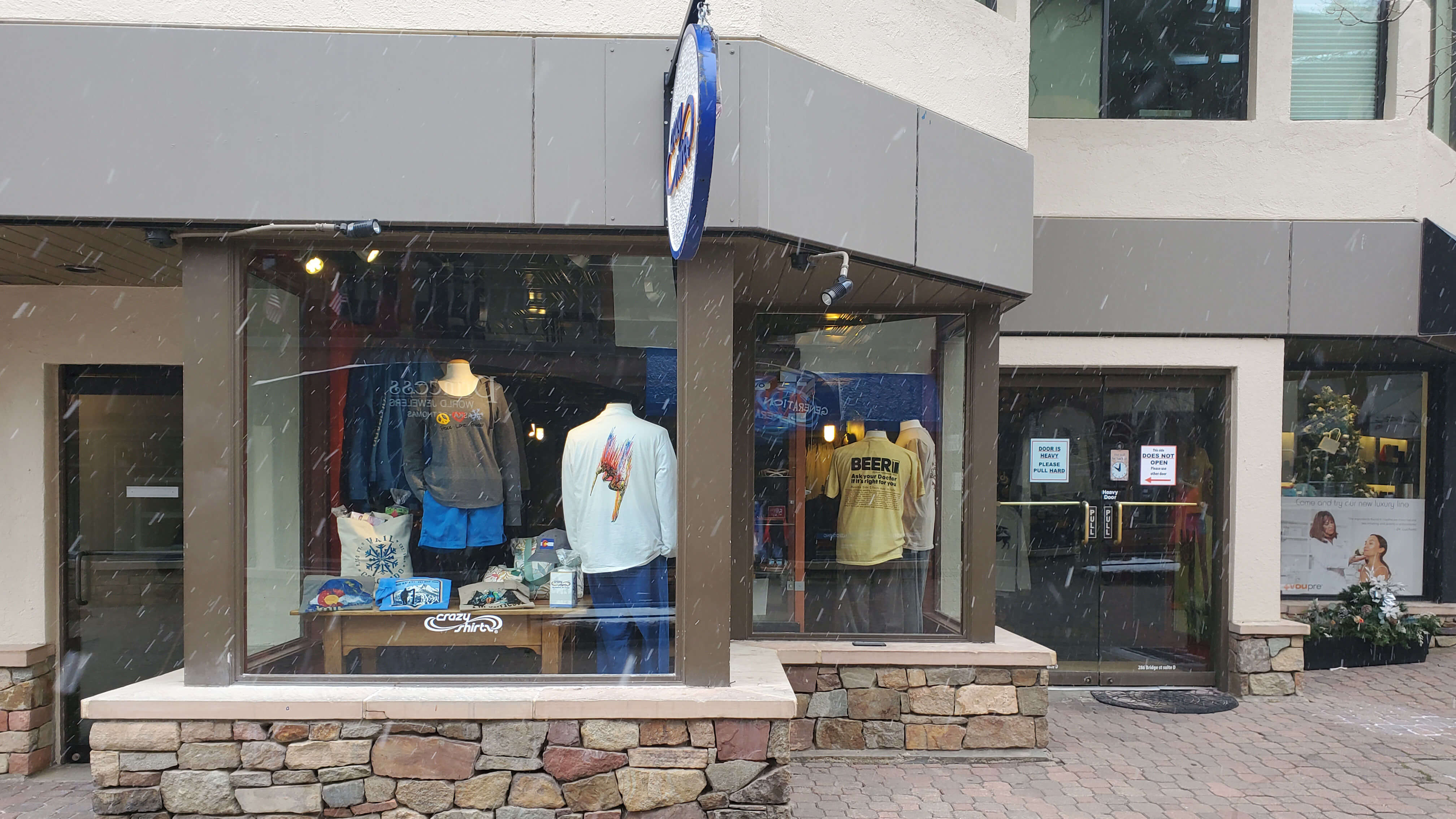 Vail Crazy Shirts storefront with mannequins wearing clothing and a visible brand logo.
