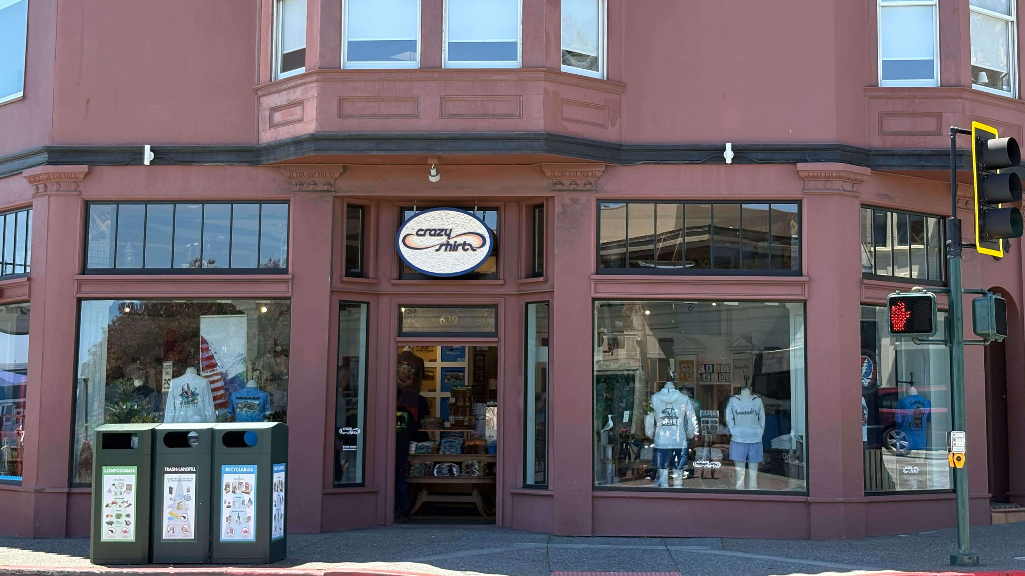 Crazy Shirts red brick building with a store front featuring a sign, on a city street.