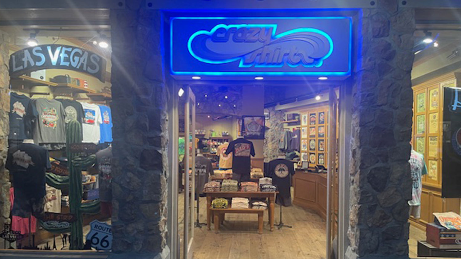 Storefront with 'Crazy Shirts' neon sign and merchandise display.